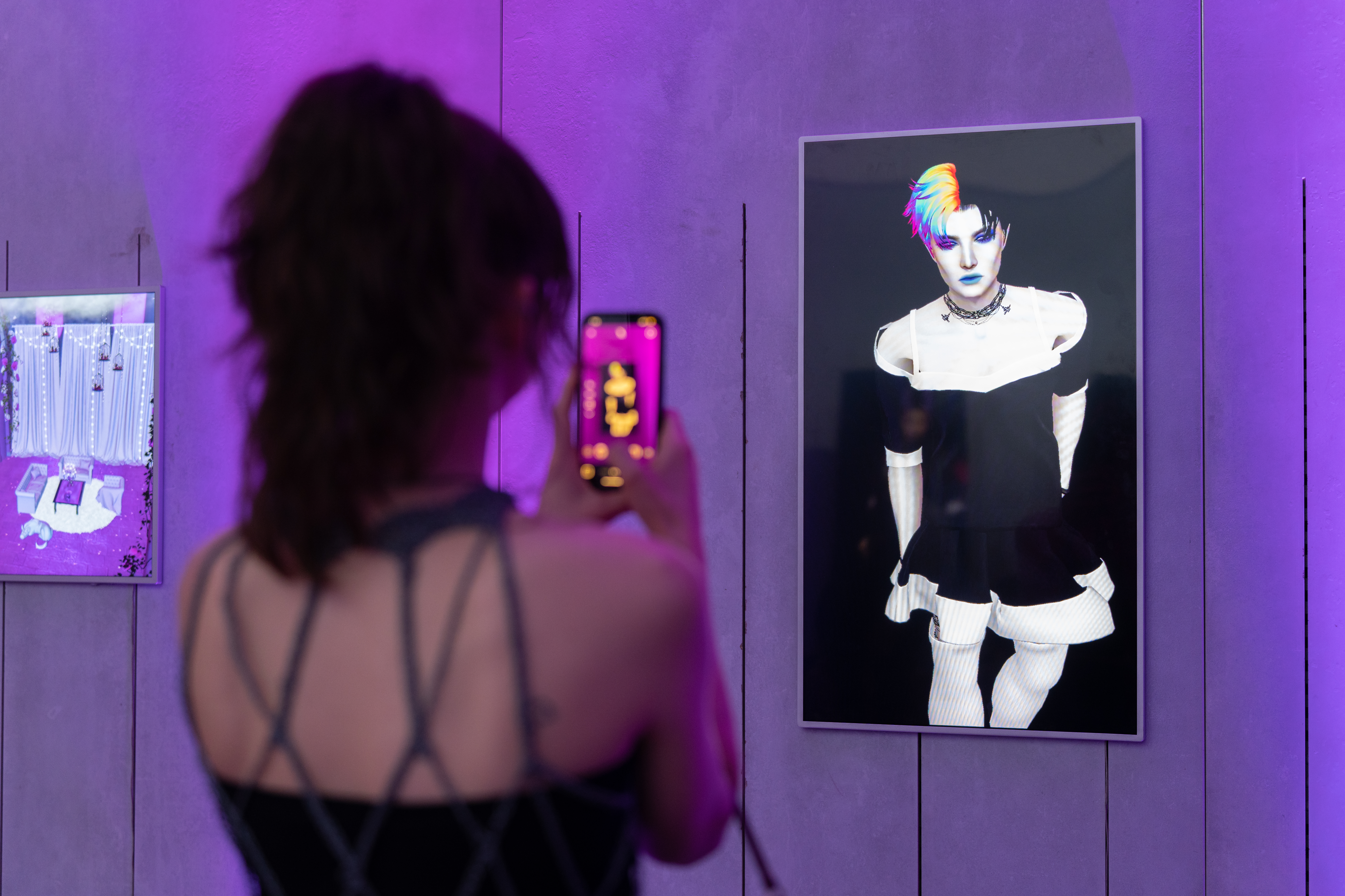 girl with iphone taking photo of a screen featuring an IMVU avatar